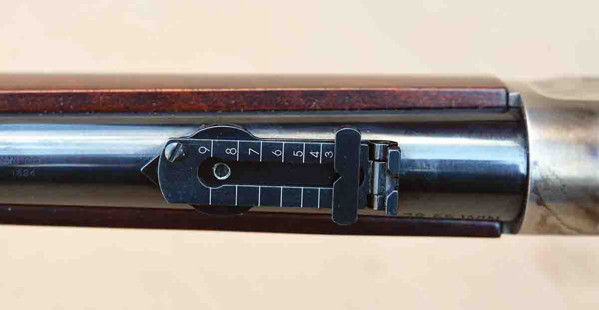The ladder rear sight features graduation markings from 2 through 9.